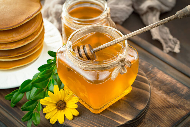 Sweet honey with flowers on an old background. - Valokuva, kuva