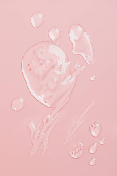 Cosmetic liquid gel serum lubricant hyaluronic acid with oxygen bubbles on a pink background. Facial body hair care. - Foto, imagen