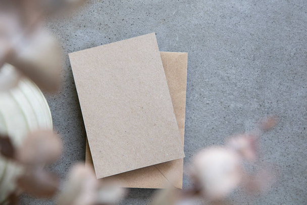 Blank kraft brown invitation stationery card with dried eucalyptus leaves - Foto, imagen