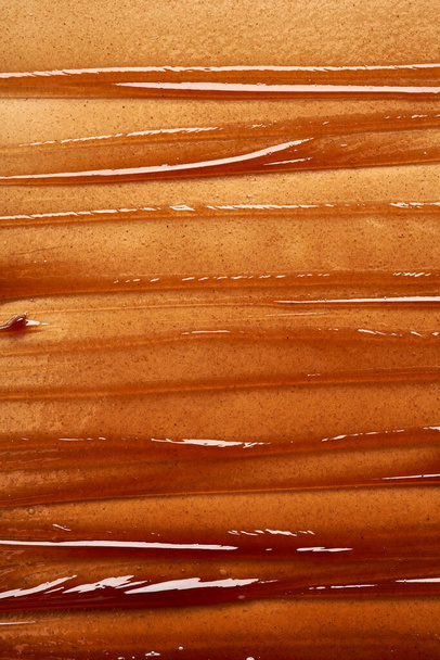 Chocolate colored gel smear and texture. Cosmetic gel or caramel syrup on white background - Foto, Bild