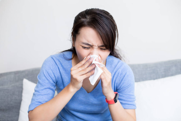 sick asian woman sneeze with tissue in the living room at home - Foto, afbeelding