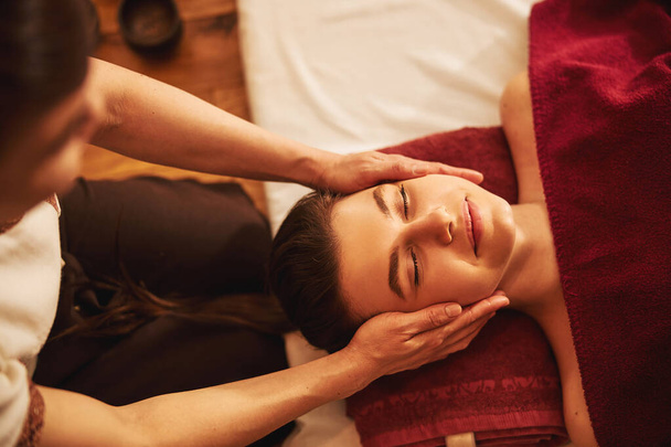 Gezicht van tevreden dame ontvangen massage van wangen - Foto, afbeelding