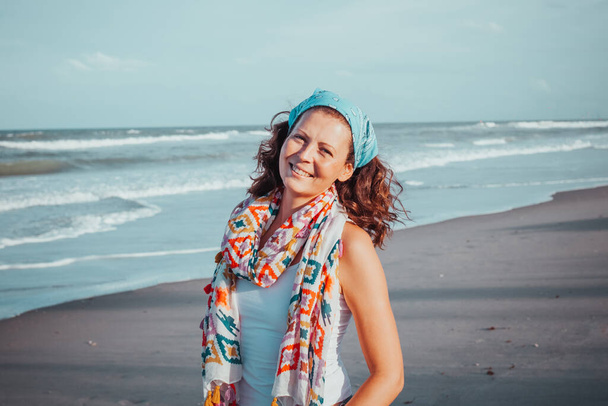 Bosá mladá etnická žena kráčející po písčité pláži směrem k oceánu během letních prázdnin.Portrét půvabné ženy, která si užívá krásné přímořské pláně procházky v letní den. atraktivní mladý hipster - Fotografie, Obrázek