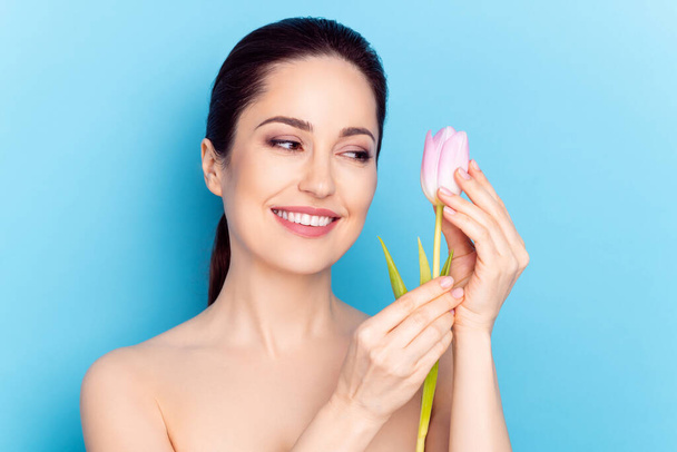 Foto de mujer atractiva sonrisa positiva feliz mirada tulipanes terapia de spa de flores aislado sobre fondo de color azul - Foto, Imagen