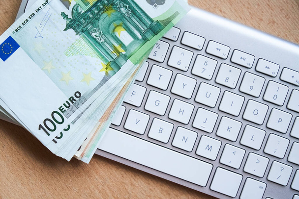 E-commerce, e-banking concept. EU euro banknotes on computer keyboard - Foto, afbeelding