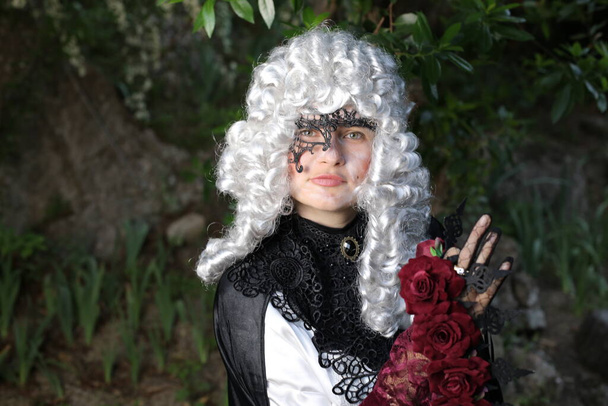 portrait of young woman in Victorian wig and dress outdoors in park - Фото, изображение