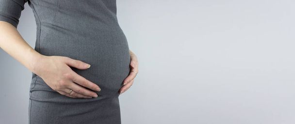 Young woman holding pregnant belly in hands. preparation and expectation concept - Φωτογραφία, εικόνα