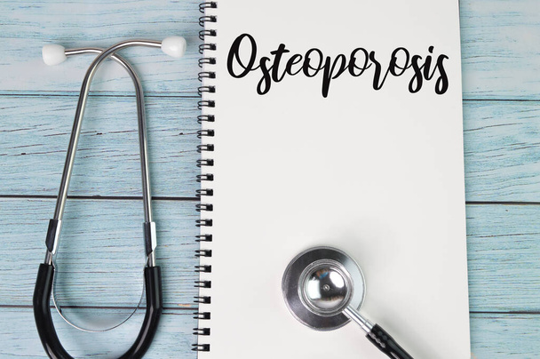 Az OSTEOPOROSIS-szal írt sztetoszkóp és notebook felső nézete. Egészségügyi koncepció - Fotó, kép