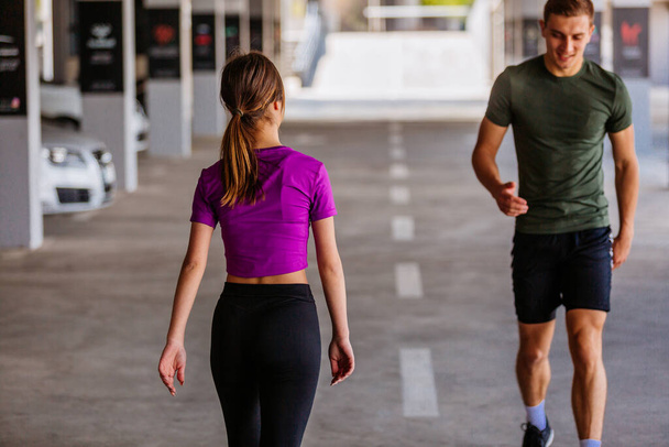 スポーツカップルは公園で一緒に走る。フィットネストレーニングの屋外で一緒にジョギングする若者。一緒にスポーツトレーニングで男と女 - 写真・画像