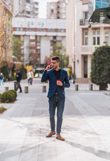 Young handsome manager in blue suit going to work - Fotoğraf, Görsel
