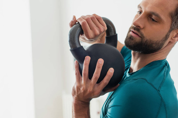 adult athletic man training with kettlebell at home - Fotó, kép