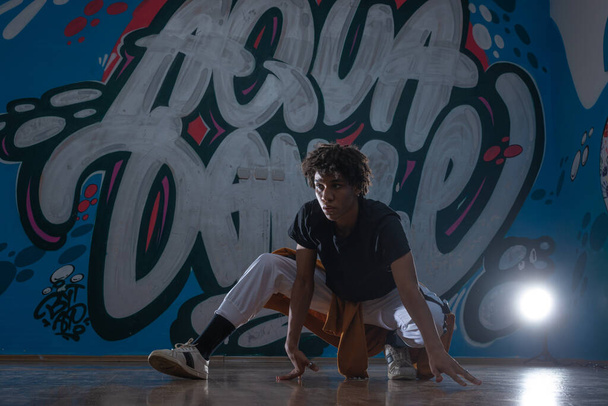 Afrikkalainen amerikkalainen hip hop tanssija (breakdancer) suorittaa yli graffiti tausta tumma siluetti altistuminen. - Valokuva, kuva