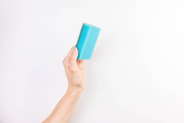 vrouw de hand houdt een schoonmaak spons geïsoleerd op witte achtergrond - Foto, afbeelding