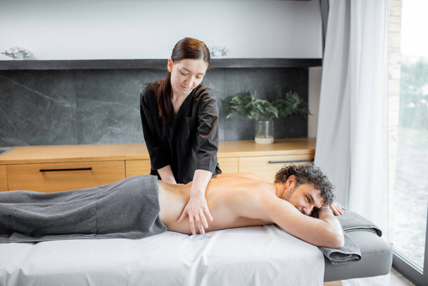 Kobieta masażystka robi masaż męskiemu klientowi. - Zdjęcie, obraz