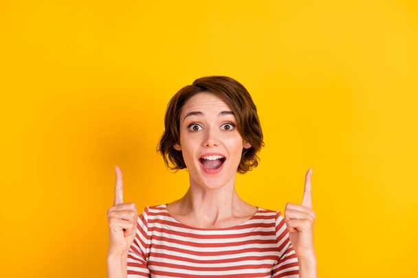 Photo of cheerful nice lady impressed direct two fingers up open mouth isolated on yellow color background - Photo, image