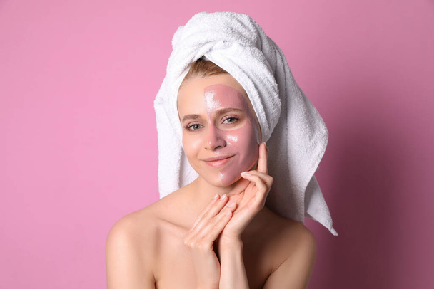 Young woman with pomegranate face mask on pink background - Fotó, kép