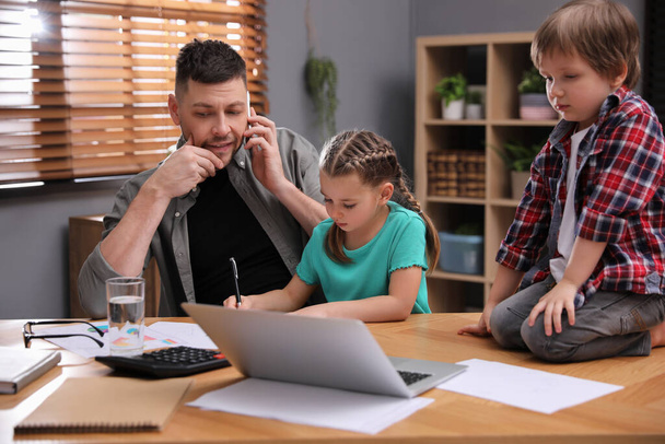 Overwhelmed man combining parenting and work at home - Foto, Imagen