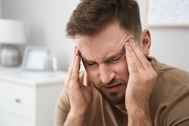 Młody mężczyzna cierpiący na migrenę w domu, zbliżenie - Zdjęcie, obraz