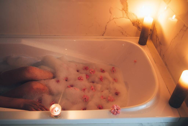 Bad met kaarsen en sakura bloemen. Ontspanning - Foto, afbeelding
