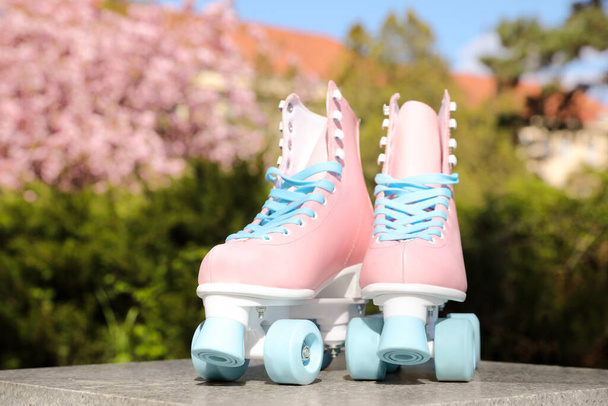 Stylish pink roller skates outdoors on sunny day - 写真・画像