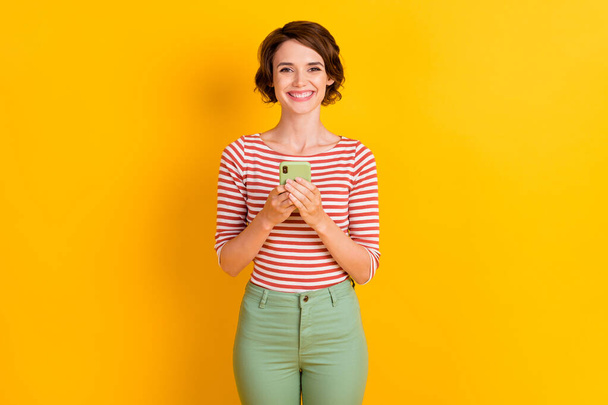 Portrait of satisfied person hands holding smartphone positive blog isolated on vibrant yellow color background - Photo, Image