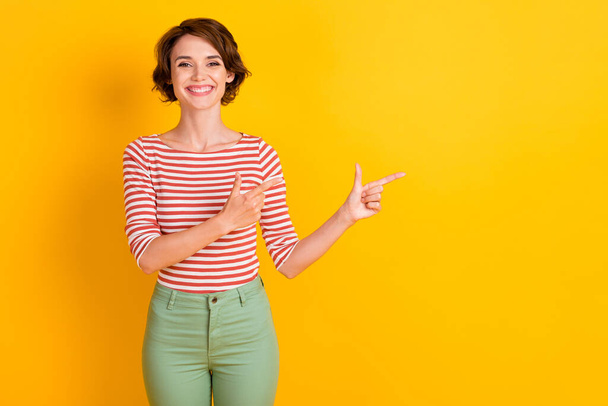 Portrait of friendly person smile direct two finger empty space banner isolated on vivid yellow color background - Фото, зображення
