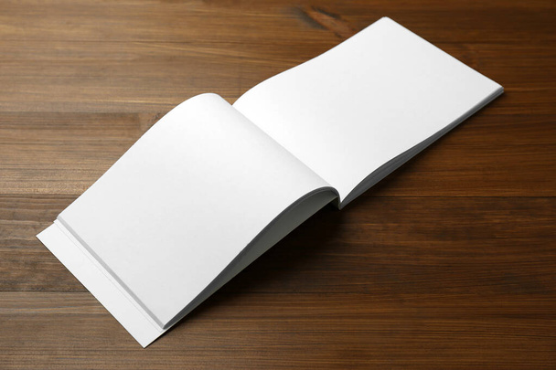 Open blank paper brochure on wooden table. Mockup for design - Фото, изображение