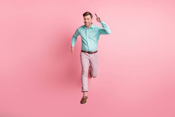 Full length photo of charismatic young man run you jump air charming smile isolated on pastel pink color background - Foto, Imagem