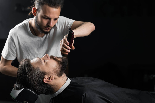 Couper la barbe avec une machine à raser. Publicité pour salon de coiffure et salon de beauté pour hommes. - Photo, image