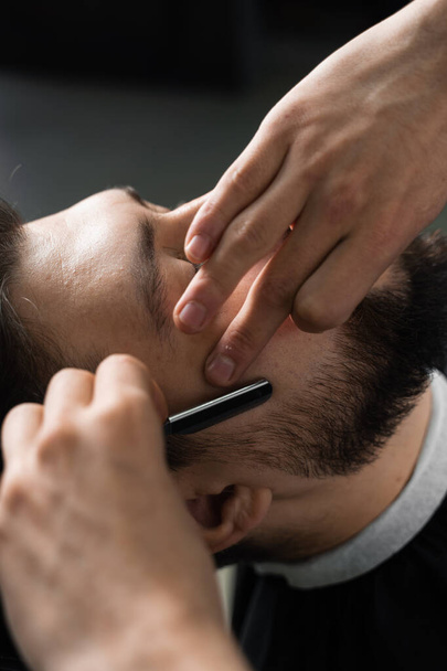 Rasiermesser schneiden Männer Bart in Friseursalon. Friseur Mann macht Frisur für gutaussehenden Mann - Foto, Bild