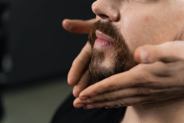 Fixing the shape of the beard with wax. The result of a haircut in a barbershop - Foto, Bild