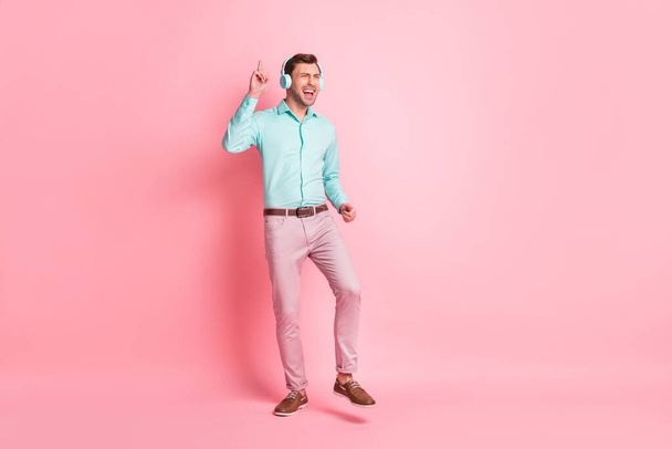 Full size photo of young happy crazy excited cheerful man dancing listen music in headphones isolated on pink color background - Fotoğraf, Görsel