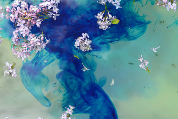 青い水に浮かぶライラックの花 - 写真・画像