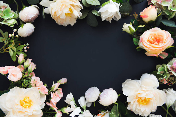 Frame van bloemen. Zomer bloeiende delicate pioenen en rozen op zwarte achtergrond, feestelijke achtergrond, wenskaart lay-out. Kopieerruimte. - Foto, afbeelding