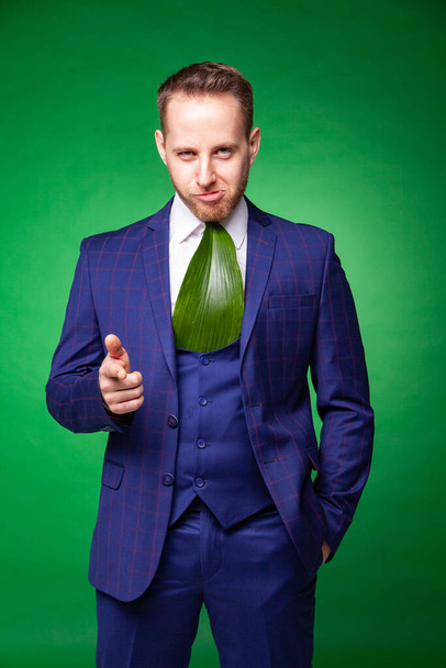 Self confident businessman in green leaf tie pointing at camera - Photo, image