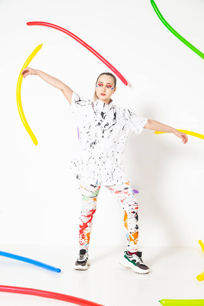 Woman in painted clothes in studio on white background - Foto, imagen
