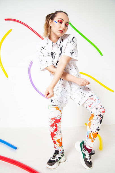 Creative woman in white clothes stained with colorful paint - 写真・画像