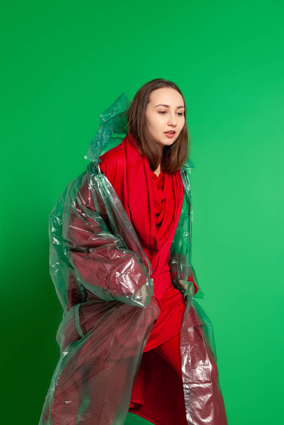 Stylish woman in plastic raincoat in studio - Photo, Image