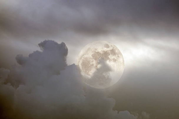 Composición fotográfica con luna llena entre nubes en una noche de overcast - Foto, Imagen