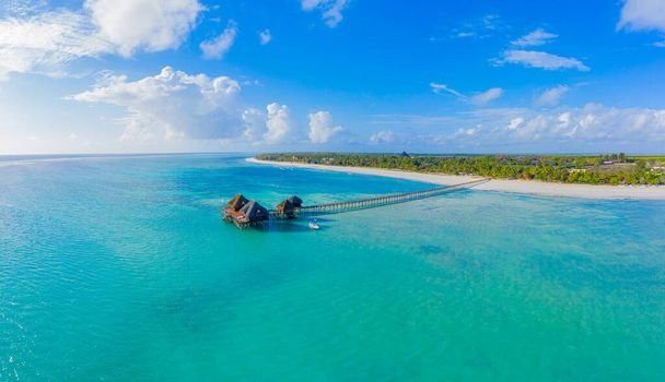 Luftaufnahme von der Insel Malediven, luxuriösen Wasservillen Resort und Holzsteg. Schöner Himmel und Meer Lagune Strand Hintergrund. Sommerurlaub und Reisekonzept. Paradiesische Luftlandschaftspanorama - Foto, Bild
