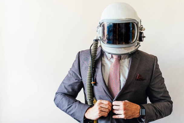Businessman with astronaut helmet looking to camera - Foto, imagen