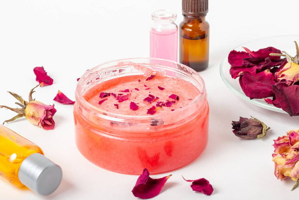 Jar of cosmetic body scrub with rose petals. Natural cosmetic. Home cosmetics - Zdjęcie, obraz