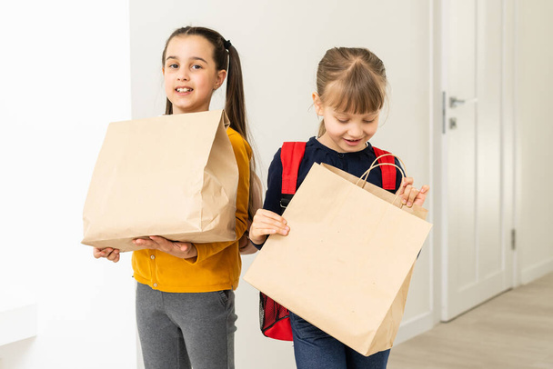 two schoolgirls with delivery packages - Foto, Imagen