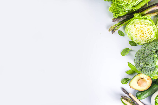 Dieta saludable Fondo de alimentos de primavera. Surtido de verduras frescas verdes orgánicas crudas - brócoli, coliflor, calabacín, pepinos, espárragos, espinacas, aguacate, col sobre fondo blanco - Foto, imagen