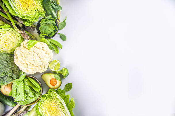 Healthy Diet Spring food background. Assortment of fresh raw organic green vegetables - broccoli, cauliflower, zucchini, cucumbers, asparagus, spinach, avocado, cabbage set on white background - Фото, зображення