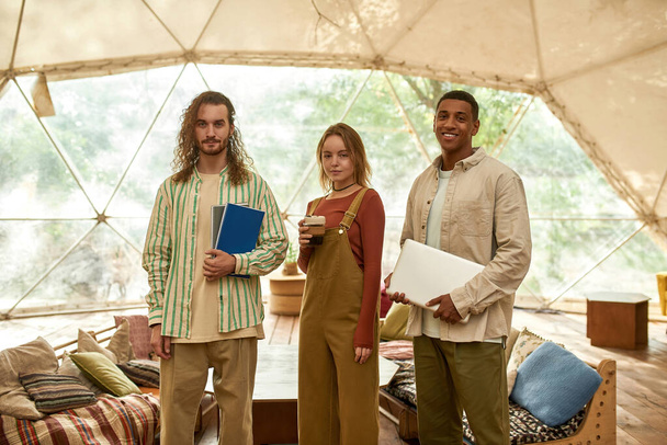 Молодая команда смешанных рас, стоящая в большой палатке - Фото, изображение