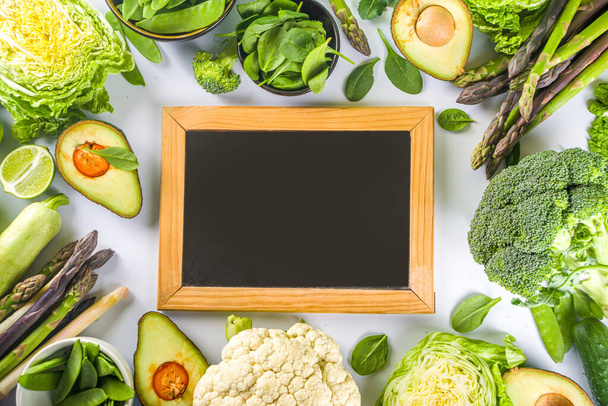 Healthy Diet Spring food background. Assortment of fresh raw organic green vegetables - broccoli, cauliflower, zucchini, cucumbers, asparagus, spinach, avocado, cabbage set on white background - Fotografie, Obrázek