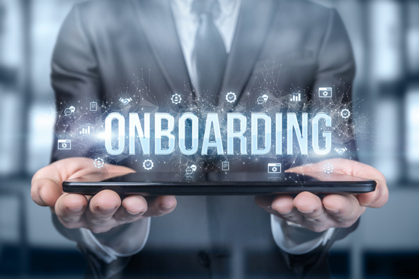 Επιχειρηματίας δείχνει στο tablet τη λέξη onboarding σε ένα θολό φόντο. - Φωτογραφία, εικόνα