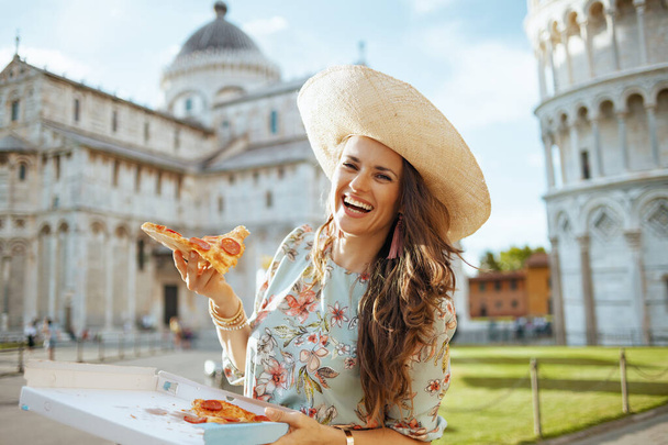 happy modern woman in floral dress with pizza and hat near Duomo di Pisa. - Foto, imagen