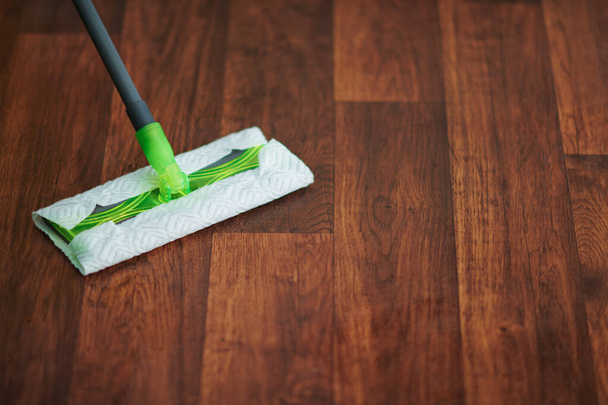 Household time. Closeup on mop and floor in the modern living room - Foto, Imagem